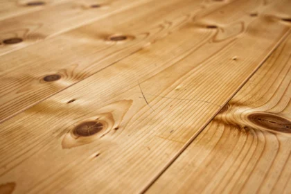 Plancher en parquet massif de pin avec grain naturel, nœuds et légères rayures visibles en gros plan
